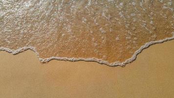 Soft wave of ocean on sandy beach photo