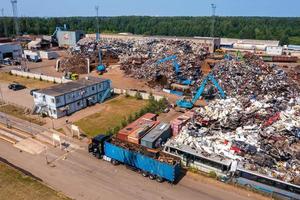 Old damaged cars on the junkyard waiting for recycling photo