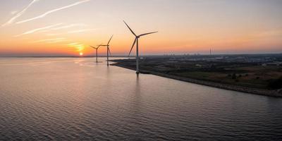 Aerial view of the wind turbines. Green ecological power energy generation. Wind farm eco field. Offshore and onshore windmill farm green energy at sea