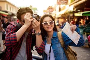 joven pareja de turistas asiáticos tomando una foto en bangkok, tailandia