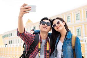 joven pareja de turistas asiáticos tomando un selfie en bangkok, tailandia foto