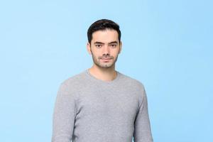 Waist up portrait of young handsome European man in plain gray t-shirt isolated in light blue bakground photo