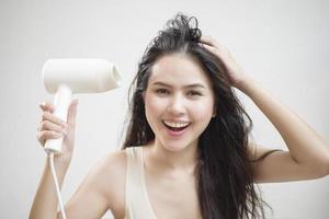 A woman is drying her hair after showering photo