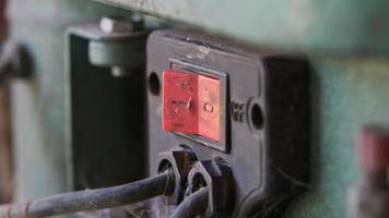 primer plano del interruptor de encendido y apagado de una máquina perforadora en el taller.