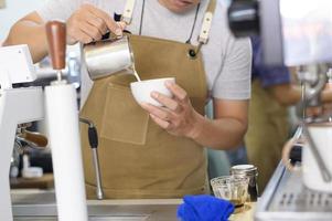 Barista making hot latte art in coffee shop photo