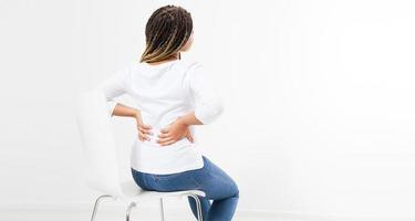 beautiful woman suffering from backache on chair - back view, female rheumatism copy space