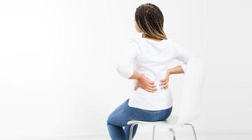 beautiful woman suffering from backache on chair - back view, female rheumatism copy space