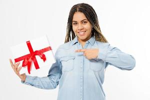 mujer afroamericana con rastas apuntando a una caja de regalo aislada foto
