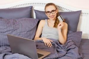 White woman doing online shopping, using her credit card to pay photo