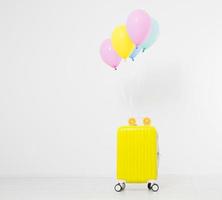 Colorful balloons and suitcase isolated on white background.Holidays concept. Copy space photo