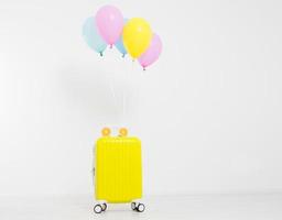 Colorful balloons and suitcase isolated on white background.Holidays concept. Copy space photo