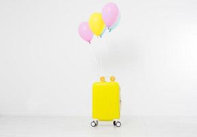 Colorful balloons and suitcase isolated on white background.Holidays concept. Copy space photo
