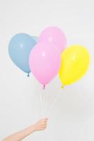 Hand holding balloons. Holiday concept. Colorful party balloons background. Isolated on white. Copy space photo