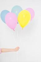 Hand holding balloons. Holiday concept. Colorful party balloons background. Isolated on white. Copy space photo