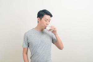 joven asiático con un vaso de agua en la mano foto