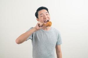 young Asian man with fried chicken on hand photo