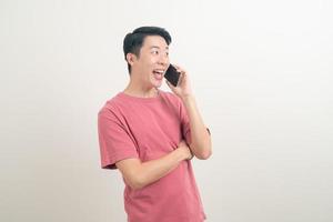 young Asian man using or talking smartphone and mobile phone with happy face photo