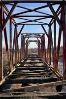 túnel de metal abierto en el puente. ferrocarril de cuco sobre el pantano. foto