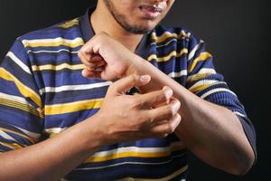 man suffering from itching skin, close up. photo