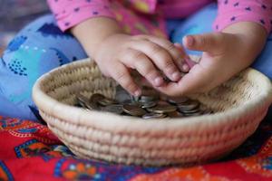 child girl pile coin for saving. sitting on floor