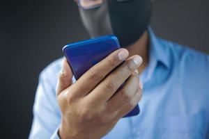 hombre enfermo con mascarilla quirúrgica usando un teléfono inteligente, enfoque selectivo foto