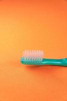 cepillo de dientes verde sobre fondo naranja foto