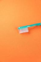 cepillo de dientes verde sobre fondo naranja foto
