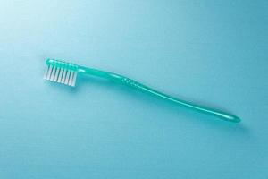 cepillo de dientes verde sobre fondo azul foto
