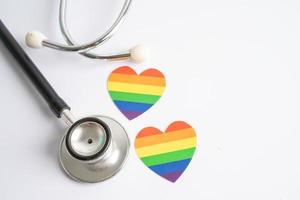 Black stethoscope with rainbow flag heart on white background, symbol of LGBT pride month  celebrate annual in June social, symbol of gay, lesbian, bisexual, transgender, human rights and peace. photo