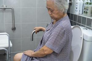 Asian senior or elderly old lady woman patient use toilet bathroom handle security in nursing hospital ward, healthy strong medical concept. photo