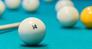 Green billiard table with white balls and cue. Closeup photo