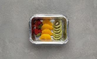 fast food in a foil box on a gray background. a healthy food close up photo
