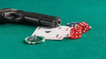 Poker chips, cards and gun on a green background. The concept of gambling and entertainment. Casino and poker photo