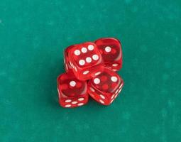 group of red playing dice on a green background, isolated. top view photo