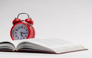 red alarm clock and open book on white background, isolated. back to school photo