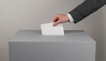 Gray ballot box. Presidential and parliamentary elections. The voter throws the ballot into the ballot box photo