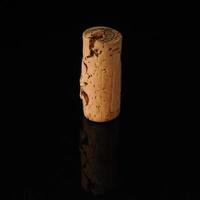 One old wine cork on black background with reflection photo