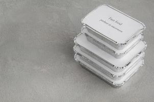 set of fast food in a box of foil on a gray rough background. food for businessman and busy people photo