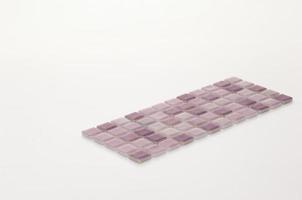 pequeño azulejo de cerámica púrpura sobre un fondo blanco, mayólica. para el catálogo foto
