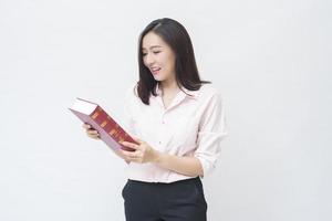 portrait of beautiful woman student in pink shirt is holding a book isolated over white background studio photo