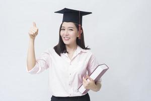 un retrato de una hermosa joven asiática con gorra de educación sobre estudio de fondo blanco, concepto de educación. foto