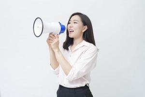 una joven y hermosa mujer asiática está anunciando por megáfono sobre fondo blanco