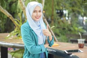 Muslim woman with hijab is working with laptop computer in coffee shop photo