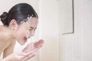 A beautiful woman is washing her face photo