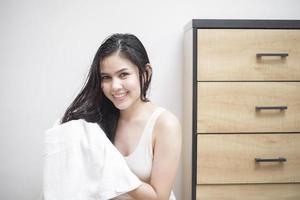 A woman is drying her hair with a towel after showering photo