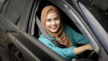 Beautiful businesswoman with hijab is smiling in her car photo