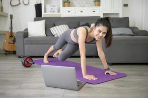 A Young beautiful woman is doing the mountain climber exercise at home photo