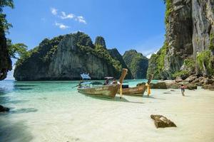 vista del barco de cola larga tradicional tailandés sobre el mar claro y el cielo en el día soleado, islas phi phi, tailandia foto