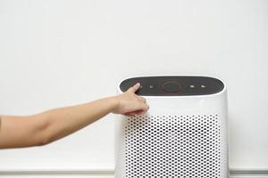 woman is turning on air purifier in home photo