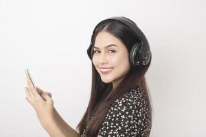mujer amante de la música está disfrutando con auriculares sobre fondo blanco foto
